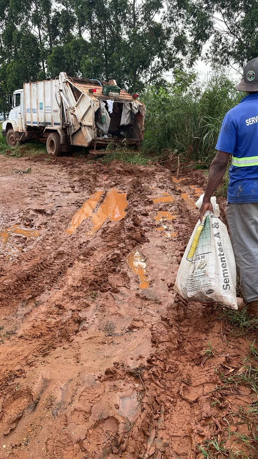 Caminhão de coleta em estrada rural tomada por lama em Itararé