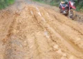 Estrada rural com lama, sulcos e uma motocicleta vermelha em Itararé, São Paulo