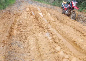 Estrada rural com lama, sulcos e uma motocicleta vermelha em Itararé, São Paulo