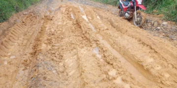 Estrada rural com lama, sulcos e uma motocicleta vermelha em Itararé, São Paulo