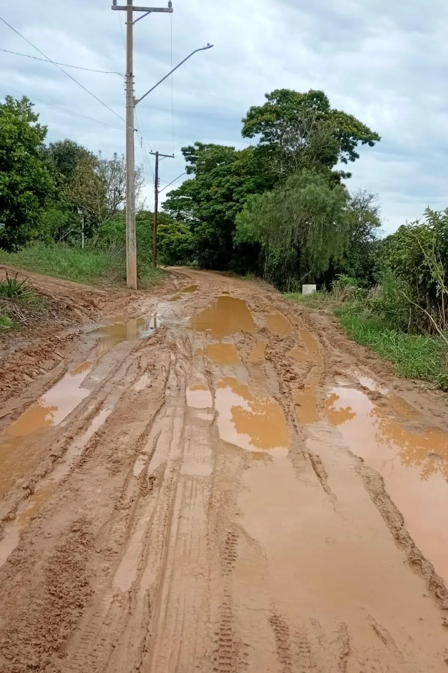 Buracos e desgaste em uma subida de estrada de terra na zona rural de Itararé